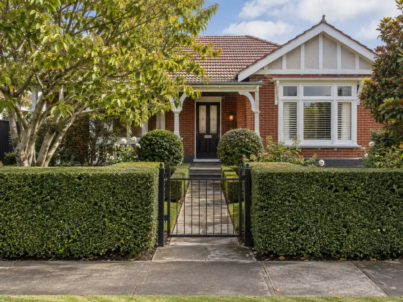 Clipped formal hedge with a flat top and square sides along the front of a villa